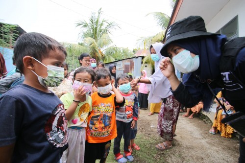 子どもたちにマスクを配るACTスタッフ　©ACT