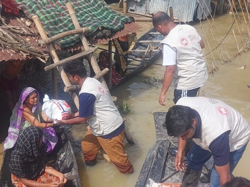 ボートを使って被災者に物資を届けるA-PADバングラデシュスタッフ。
